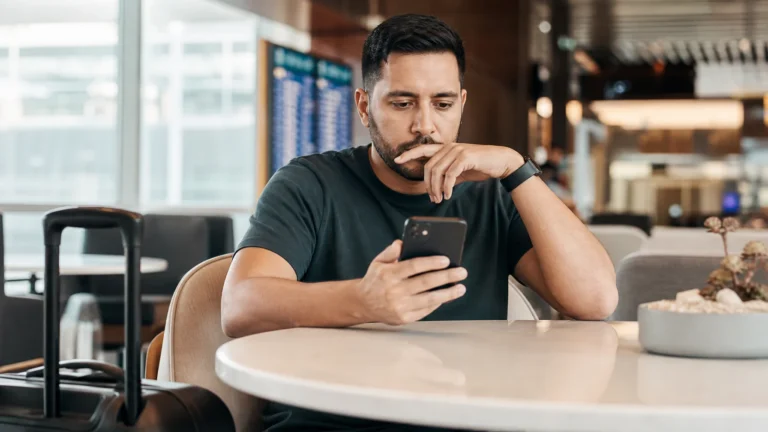Pessoa comparando os programas Livelo ou Esfera pelo celular antes de usar pontos